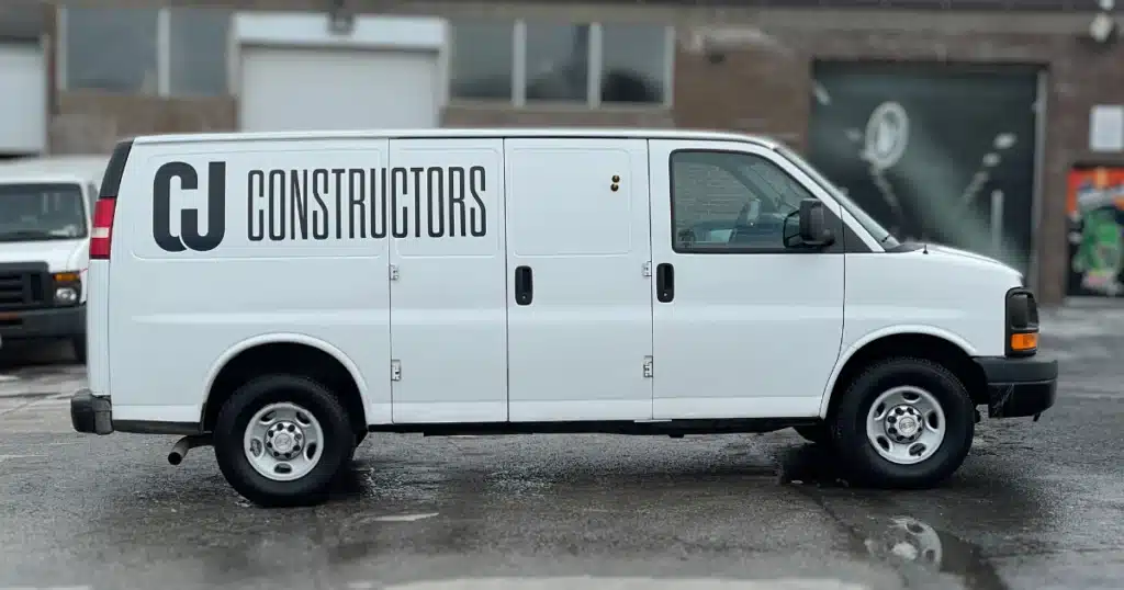 CJ Constructors Chevy Express van after the design and installation process of their van graphics. From the passenger side view.