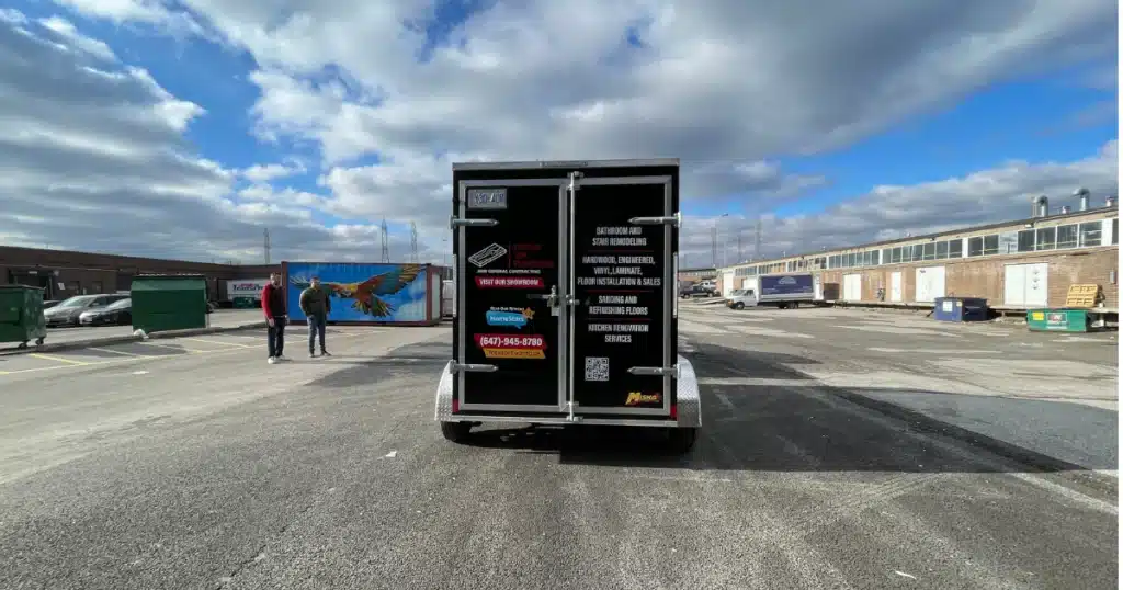 Focus on Flooring trailer branding project. Photo taken during passenger pickup. Trailer graphics seen from back view.