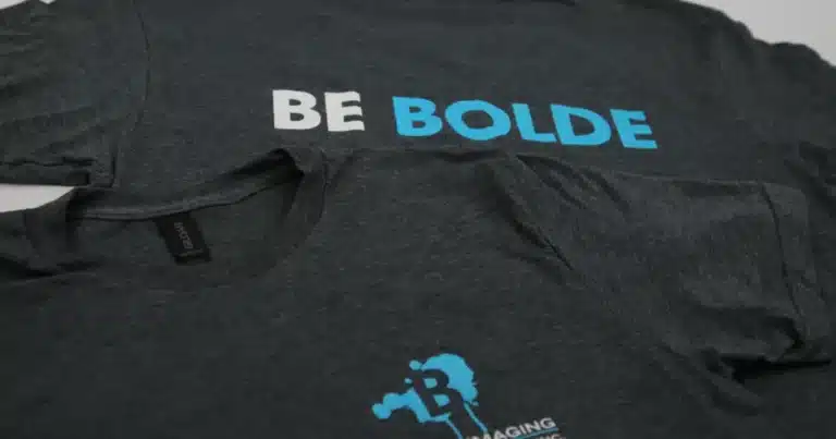 Two T-shirts featuring the Blode Imaging Group Inc logo design printed on them