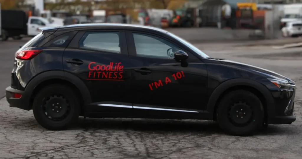 Side view of a Mazda 3 displayed with GoodLife Fitness red decals