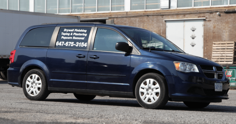 Side view of a Dodge Caravan 2015 displayed with decals